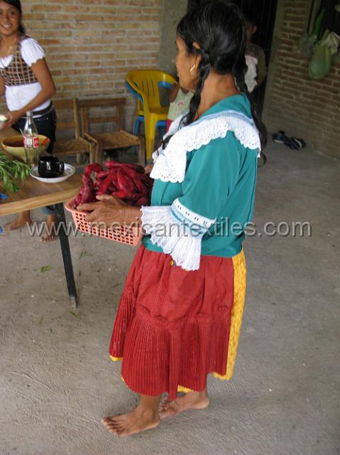 tula del rio10.JPG - This family is very industrious and bake a type of hard bread used for dunking. They color them red. This side view shows the gold skirt, red apron and aqua over blouse with the 3/4 sleeve.
